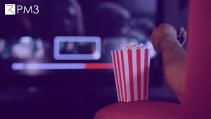Imagem ilustrativa de pessoa comendo pipoca assistindo filme, colocando em pauta a discussão entre as redes de cinema vs serviços de streaming