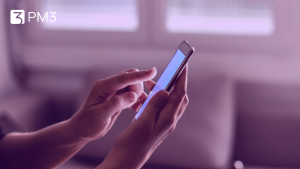 A imagem mostra duas mãos segurando um celular, representando as ações de usuários consideradas para otimização de conversão